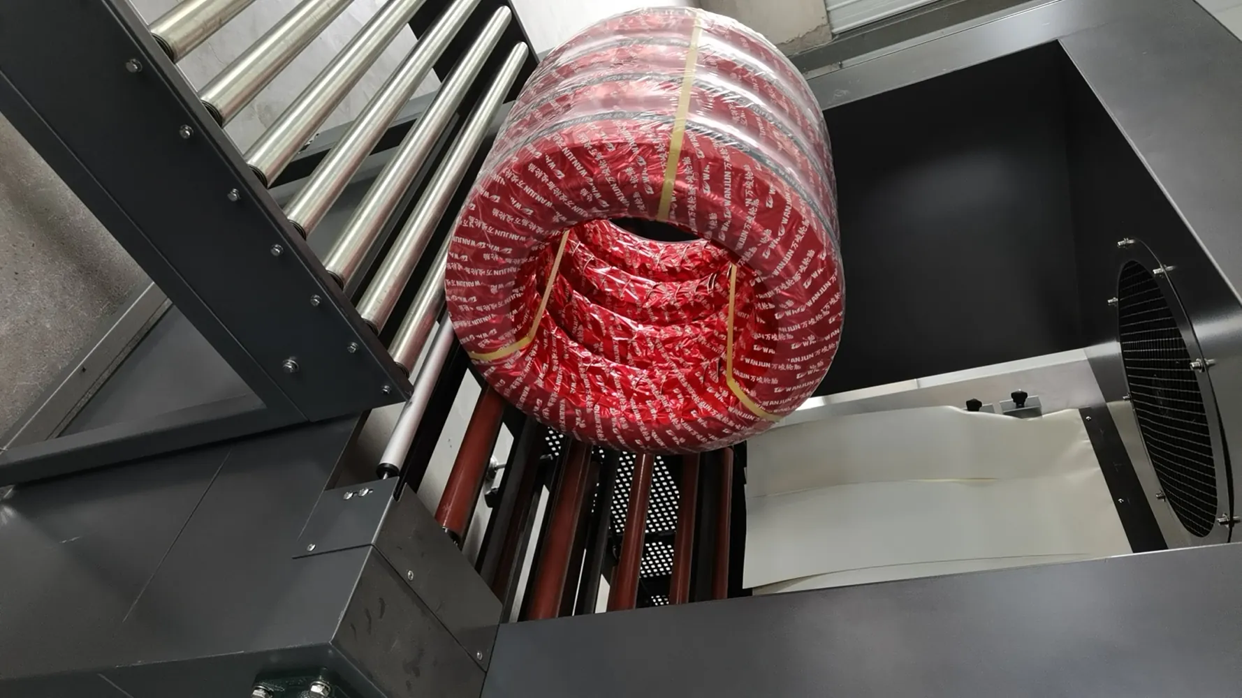 Finished tire exiting shrink tunnel